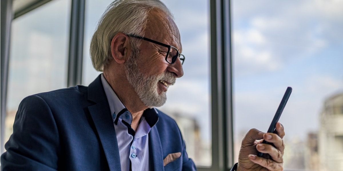 Smiling businessman looking at his cellphone