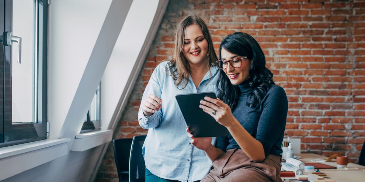 two women in office looking at document