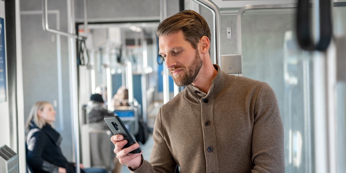 man on train looking at phone