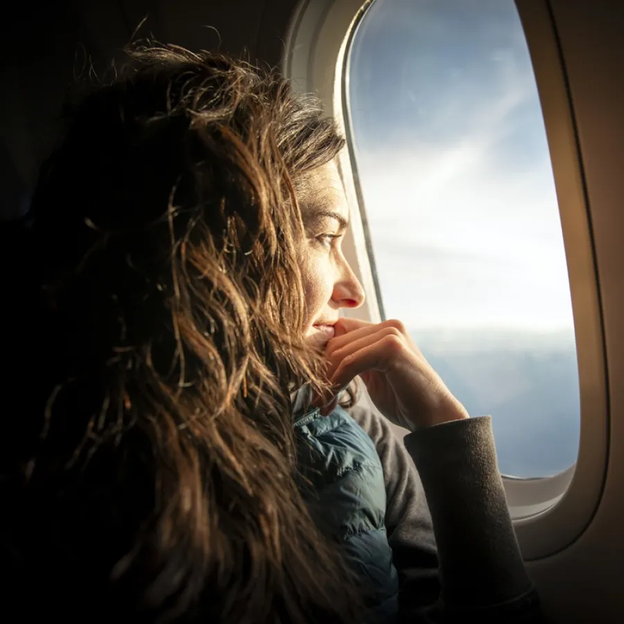Lady looking out of plane window